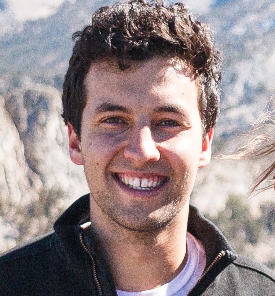 A picture of a smiling man outside with short brown hair